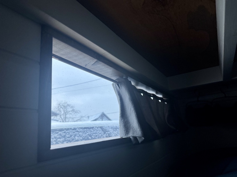 雪が降る朝にキャンピングカーの車内から見た外の様子